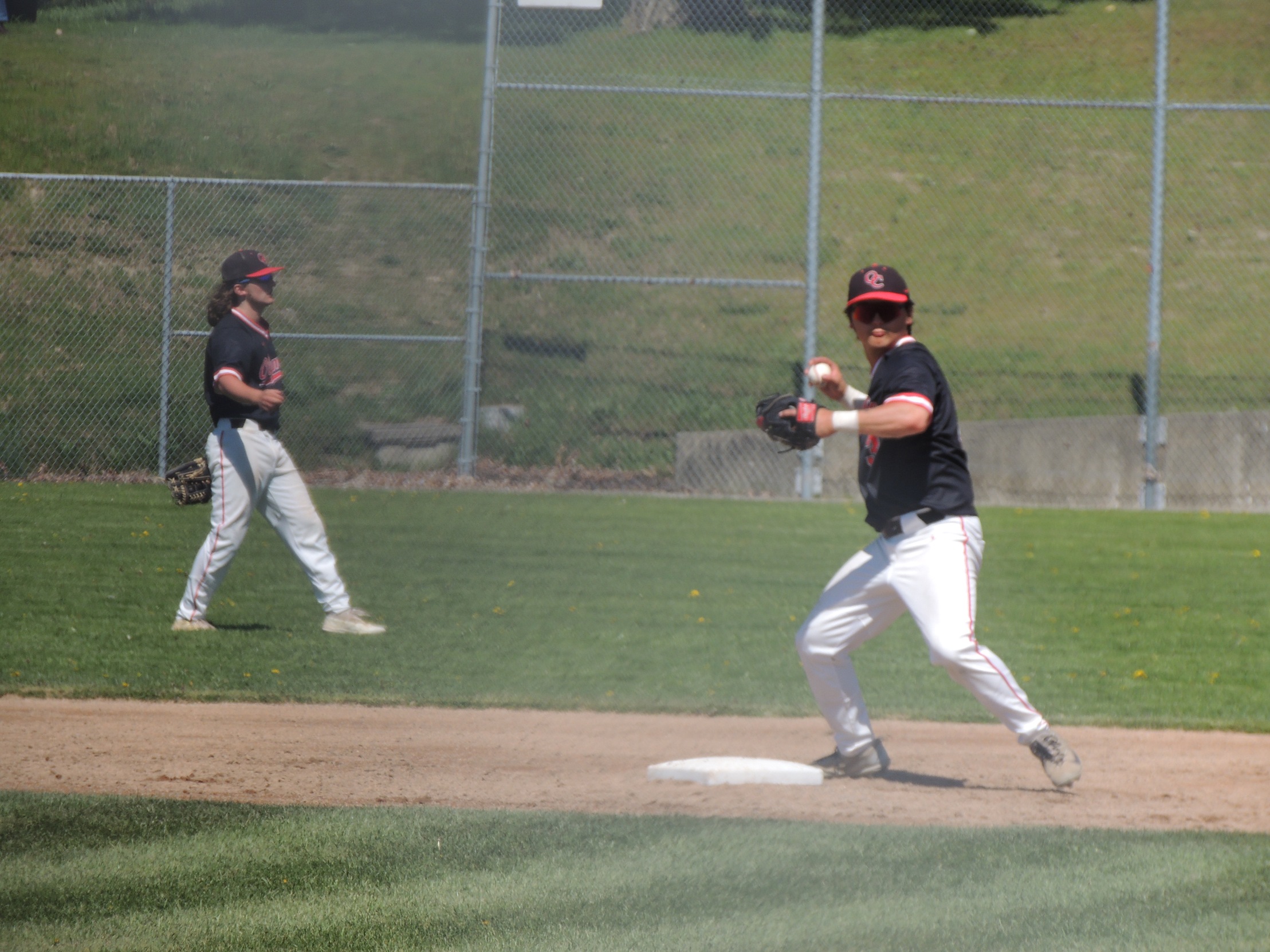 A second baseman throws the ball to first base during a game.